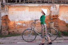 Young Woman Wearing Laos Traditional Dress With Bicycle Walking Tourism In Walking Street Chiang Khan Loei Thailand.