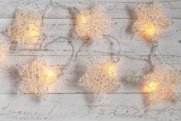 Christmas and New Year background.luminous garland in the form of stars on white  shabby chic background 