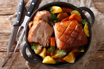 Bavarian beer roasted pork, also known as Bayerischer Schweinebraten or Krustenbraten with vegetables close-up. horizontal top view