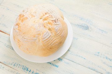 Wall Mural - Round white bread on a wooden background.