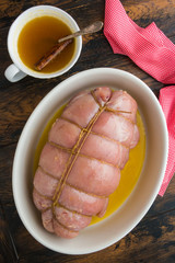 Wall Mural - Raw stuffed turkey breast fillet and sauce for baking with honey, orange juice and cinnamon. Wooden rustic table, top view