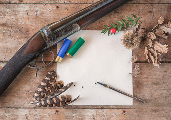 Wall Mural - Beautiful hunting season still life/ vintage hunting rifle, cartridges, vintage pen on the target with traces of bullets, pheasant feathers on old wooden background