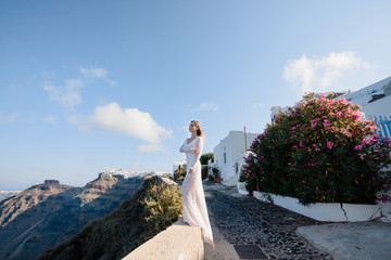 Sticker - Europe Greece Santorini travel vacation. Woman looking at view on famous travel destination. Elegant young lady living fancy jetset lifestyle wearing dress on holidays. Amazing view of sea and Caldera