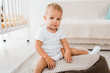 © LIGHTFIELD STUDIOS - adorable toddler sitting on bean bag chair and looking at camera indoors in nursery room