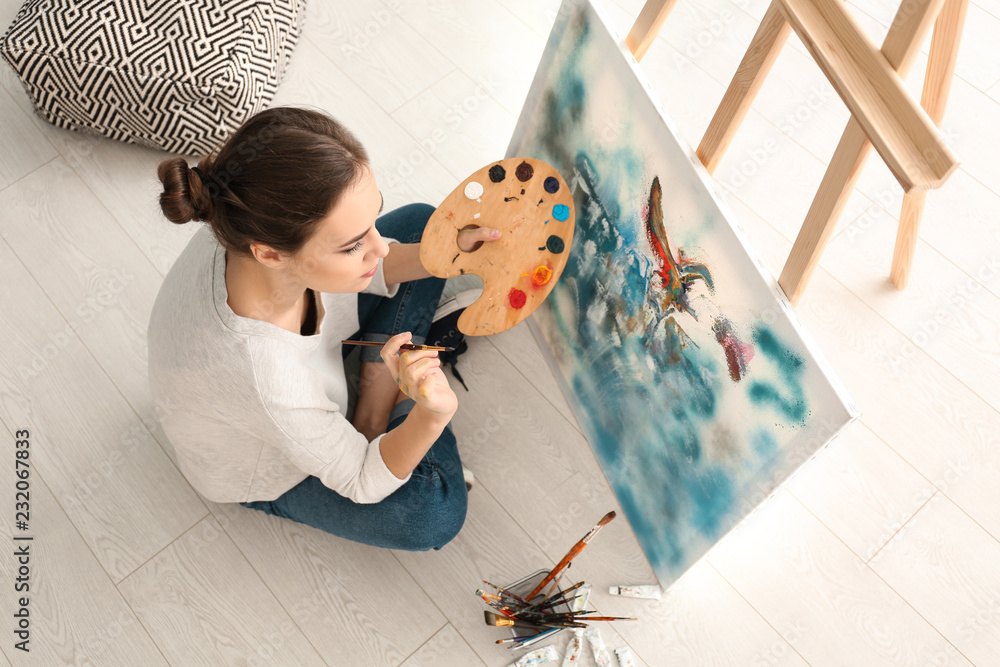 Female artist painting picture in workshop