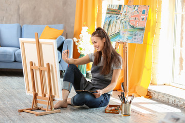 Wall Mural - Female artist painting picture in workshop