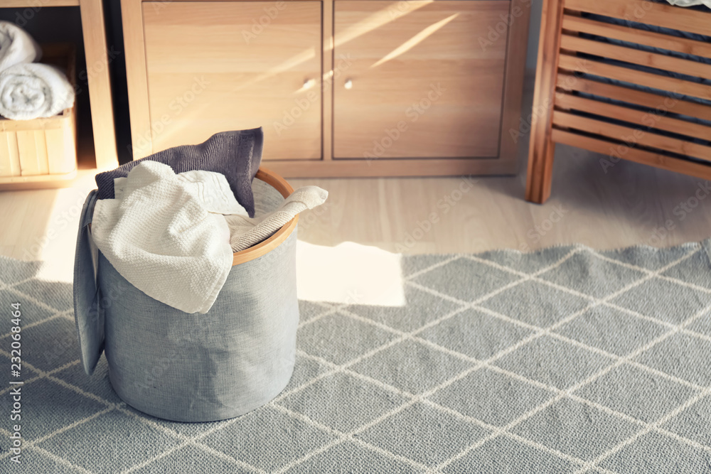 Laundry basket with dirty towels on floor in bathroom