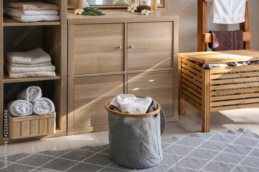 Laundry basket with dirty towels on floor in bathroom