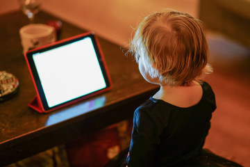 Kid looking at tablet at the night