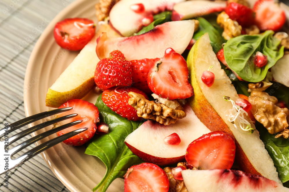 Delicious fresh salad with walnuts on plate, closeup