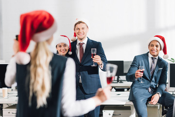 Wall Mural - happy young multiethnic business people drinking wine and celebrating new year in office