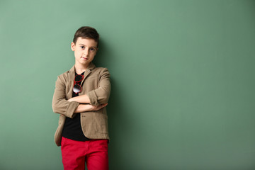 Wall Mural - Cute boy in fashionable clothes on color background