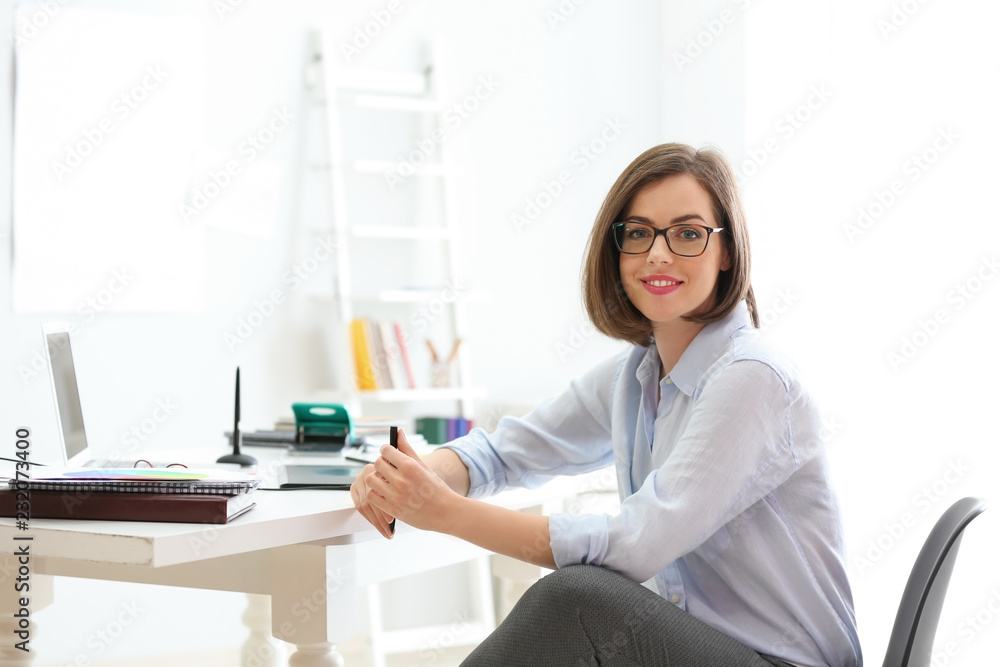 Beautiful young designer in office