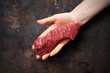 Wołowina. Kawałek surowego mięsa wołowego na kobiecej dłoni.