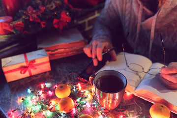 Wall Mural - man with a blank book in his hands for the New Year's table with decorations