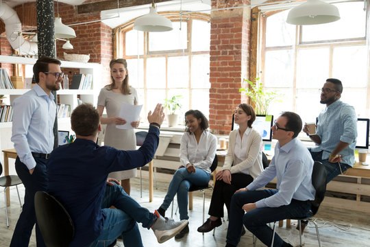 ambitious male employee raise hand ask question to female presenter at meeting, man show activity at