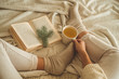© nastyaofly - Cozy winter evening , warm woolen socks. Woman is lying feet up on white shaggy blanket and reading book. Cozy leisure scene