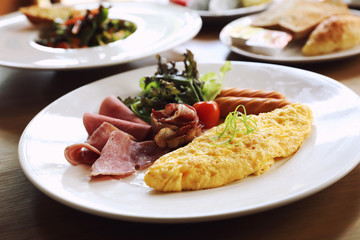 Wall Mural - Breakfast set Omelette with sausage bacon and salad on wood background