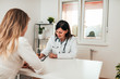 © bnenin - Female specialist writing down patients symptoms.