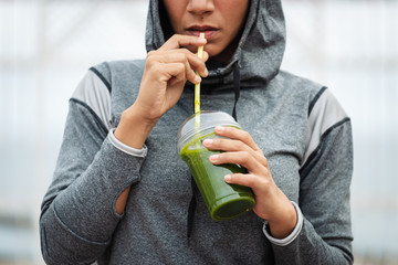 Wall Mural - Detail of sporty woman taking a rest for drinking nutritive detox smoothie. Fitness nutrition and outdoor workout concept.