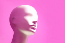 Head Of White Mannequin On Pink Background. Faceless Girl.