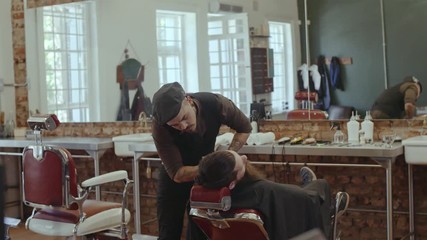 Wall Mural - Barber cutting beard with scissors at barbershop