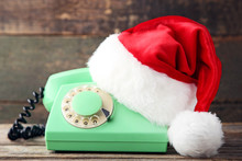 Red Santa Hat With Retro Telephone On Grey Wooden Table