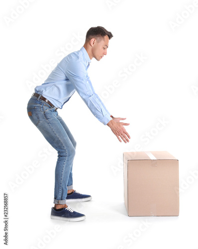 Cuadros en Lienzo Full length portrait of young man lifting heavy cardboard box on white background