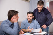 © JackF - Three men worriedly discussing documents