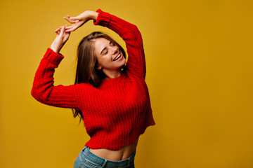 Incredible stylish modern woman wearing red shirt pulls her hands with charming smile and closed eyes, true emotion s, positive, happy mood, place for text