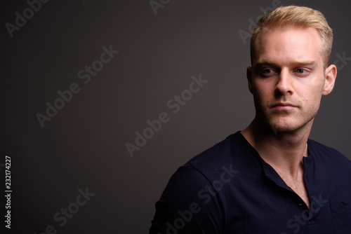 Young Handsome Man With Blond Hair Against Gray Background Buy