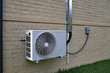 © Chad Robertson - Air Conditioner mini split system next to home with brick wall