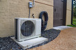 © Chad Robertson - Air Conditioner mini split system next to home with brick wall