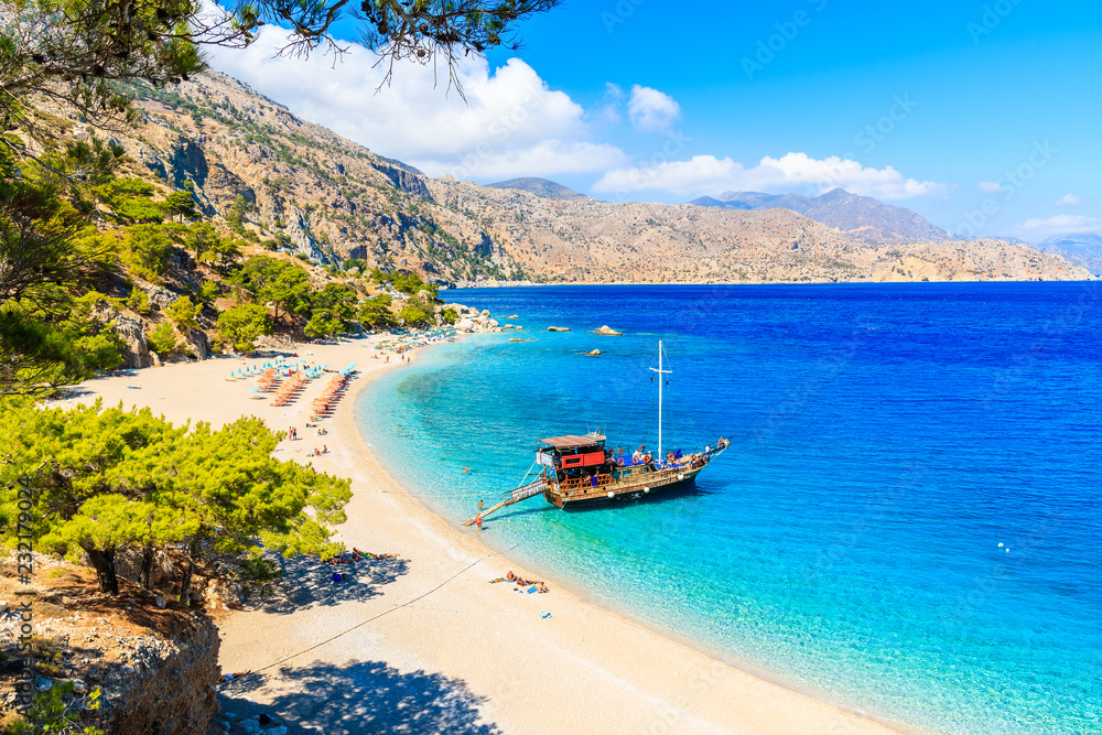 Tourist boat anchoring at beautiful Apella beach on Karpathos island, Greece - obrazy, fototapety, plakaty 