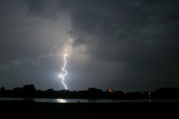 Wall Mural - a lightningbolt with curl strikes down near a river in the netherlands