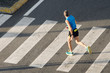 © Formatoriginal - Athlete running man. Male runner passing crosswalk
