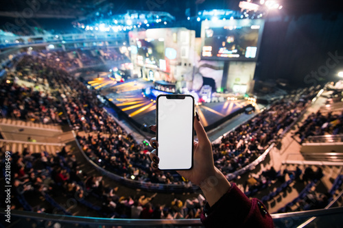 Photo  Woman's hands using digital application on the mobile smart phone at esport event at big arena