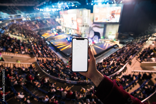 Cuadros en Lienzo Woman's hands using digital application on the mobile smart phone at esport event at big arena