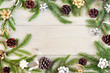 © Ekaterina - Fir branches are arranged in a circle on a light wooden background. They are decorated with bows, ribbons and cones. Beautiful Christmas composition with copy space.