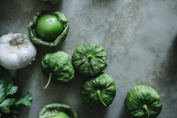 Wall Mural - Garlic and green tomatillos on a gray table