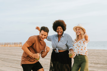 Wall Mural - Friends dancing and having fun at the beach