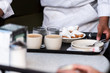 © Kristina Blokhin - New Orleans, USA Famous cafe restaurant in Louisiana old town city with waiter placing tray at table with popular pastry beignets donut