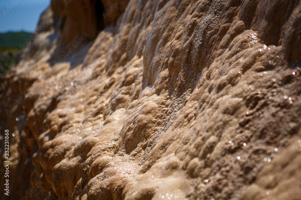 Texture yellow and beige wet uneven bumpy stone glitters in the sun ...