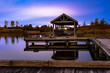 Wooden pier on the lake at blue hour after sunset.