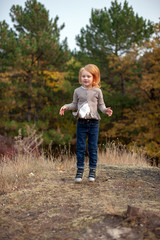 Wall Mural - Redhead girl in a jump in the forest