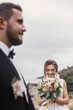 © sonyachny - Gorgeous happy bride with modern bouquet looking at stylish groom and smiling outdoors. Sensual wedding couple posing. Romantic moments of newlyweds. Wedding photo