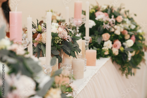 Stylish Beautiful Bouquets With Roses And Candles On Pastel Table