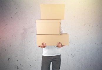 Wall Mural - Delivery man carrying stacked boxes in front of face against