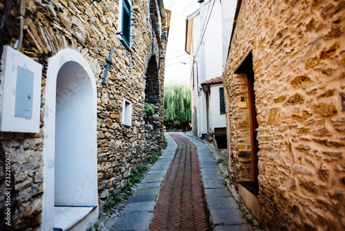 Plakat starożytna wioska na zapleczu Ligurii, wąskie uliczki i kolorowe ściany
