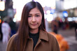 © blvdone - Young Asian woman in city at night serious face